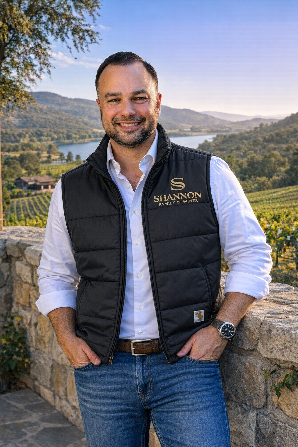 Shannon Family of Wines team member outdoors with vineyard and mountains in background.