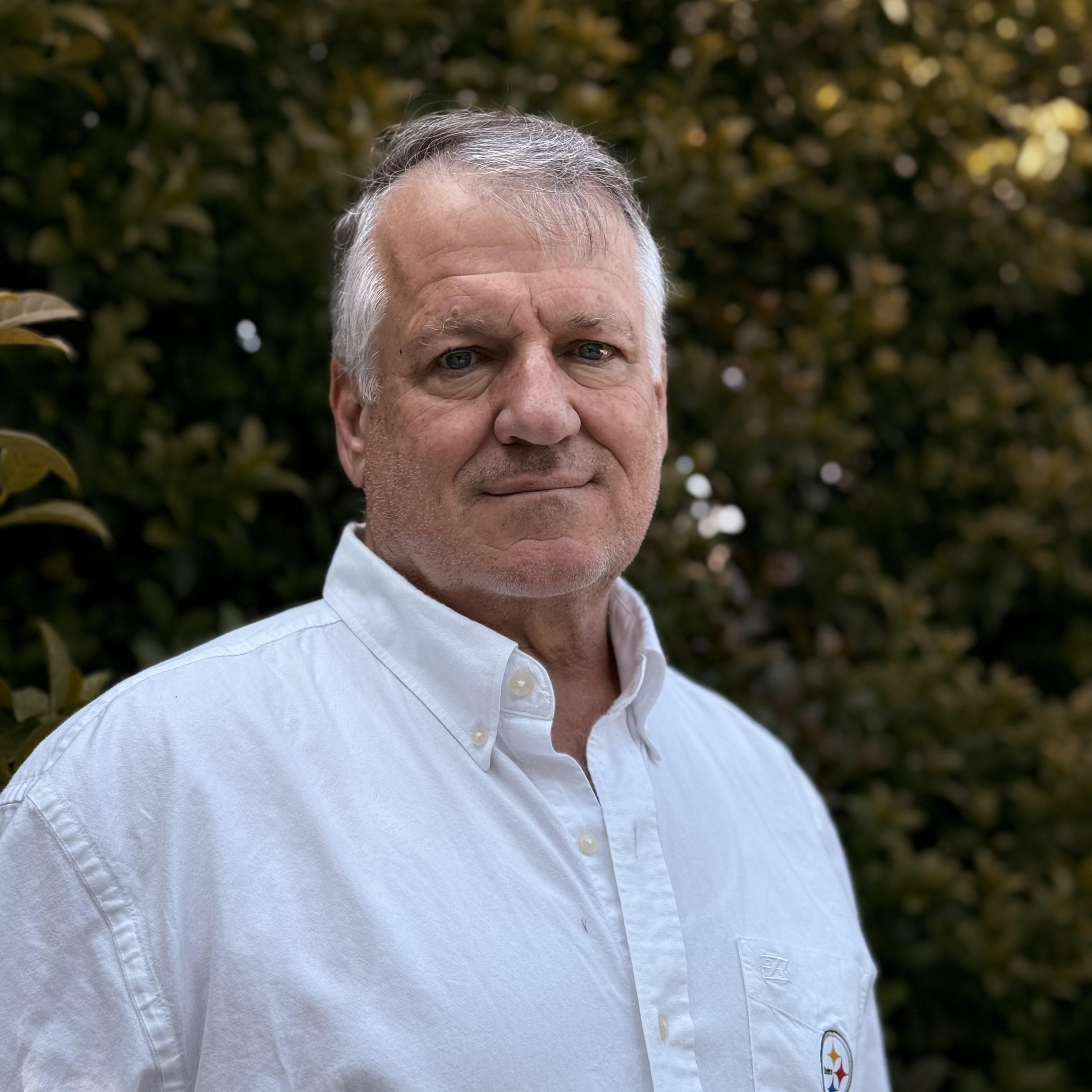 Portrait of a mature man in a white shirt outdoors, representing the Shannon Family of Wines team.